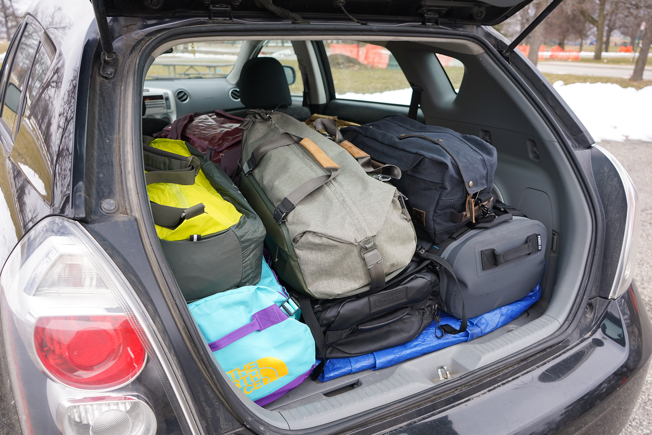 Duffle Bags Stacked In The Trunk Of A Car